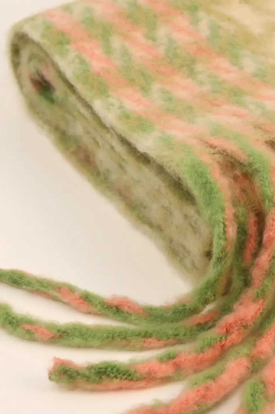 Suave y esponjosa, bufanda combinada en tonos pastel y verde oliva entrelazados en un diseño clásico de pata de gallo. Atelier Federici, Altea